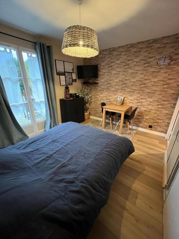 une chambre avec un grand lit et une table dans l'établissement Chez Jules, à Honfleur