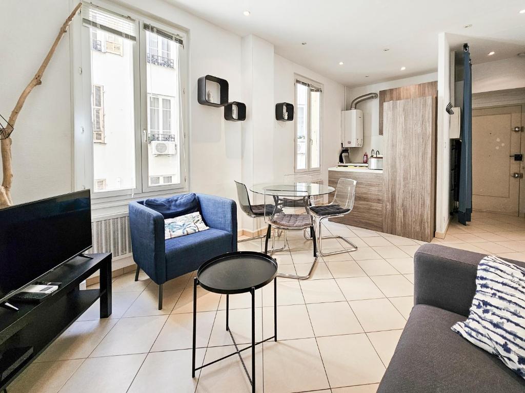un salon avec un canapé, une table et des chaises dans l'établissement Fontaine 4 Pers AC WiFi, à Nice