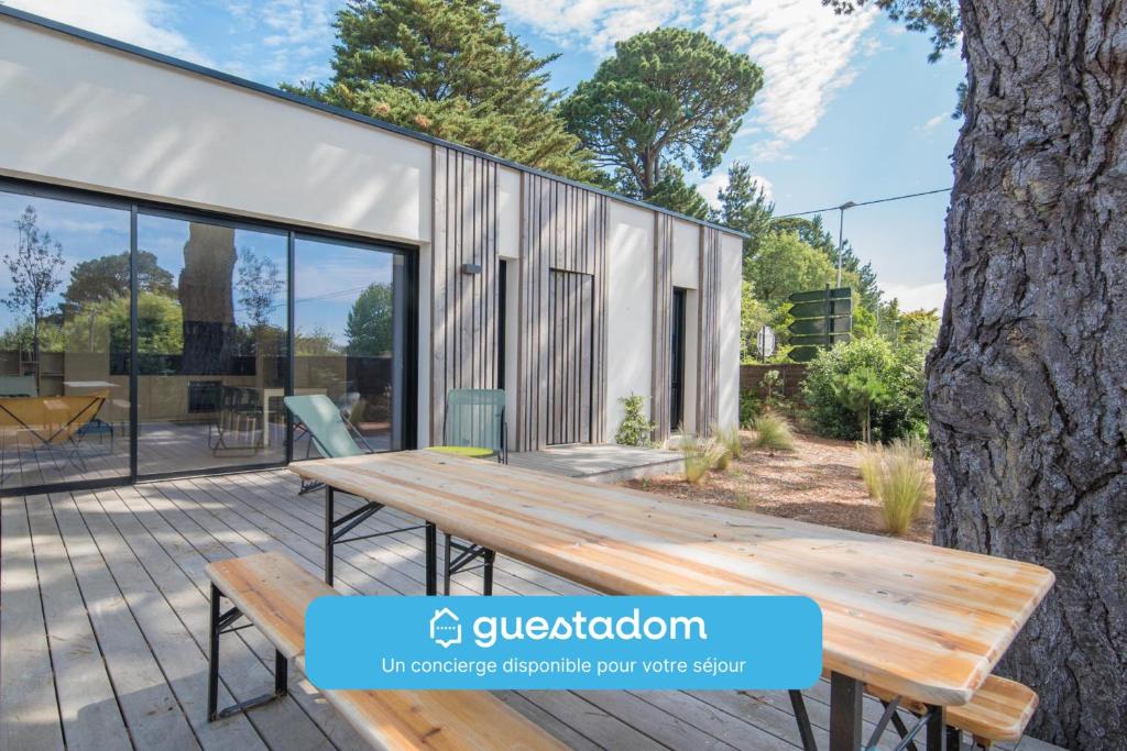 Une table de pique-nique en bois est installée sur la terrasse d'une maison. dans l'établissement Sekoya Sundeck - Proche plage - golf, à Pornic