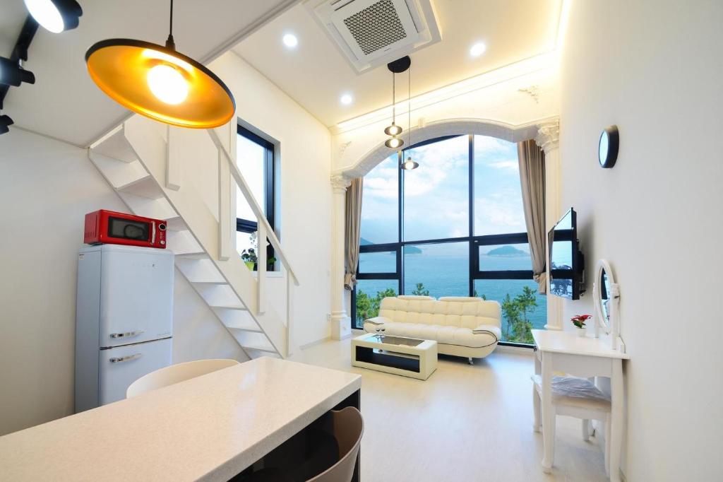a living room with a staircase and a couch at Yeosu Tivoli Pension in Yeosu