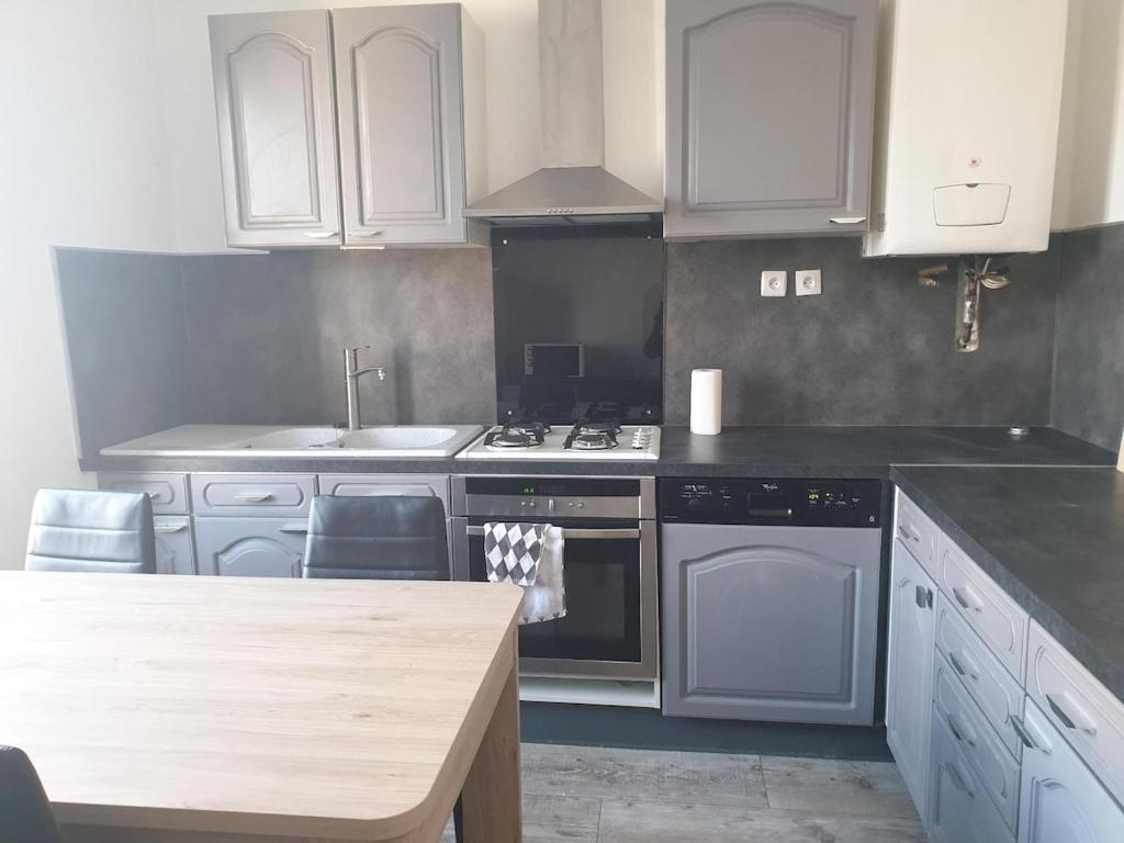 une cuisine avec des armoires blanches et un four à plaques de cuisson dans l'établissement Mt St Martin ,1er étage, 3 lits doubles séparés, à Mont-Saint-Martin