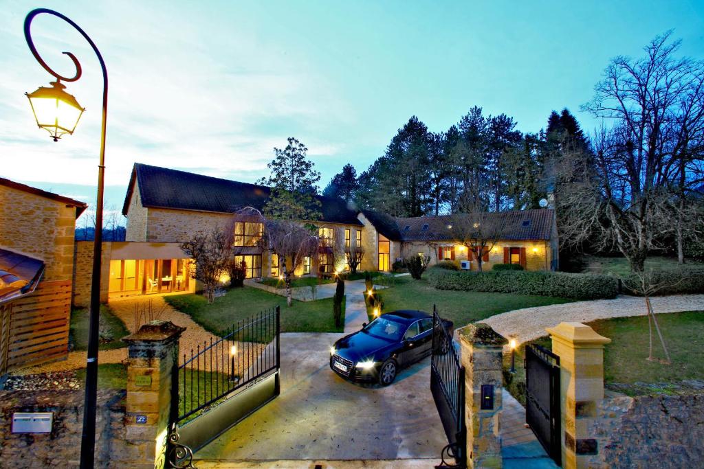 um carro estacionado na entrada de uma casa em Les Jardins du Porche em Sarlat-la-Canéda