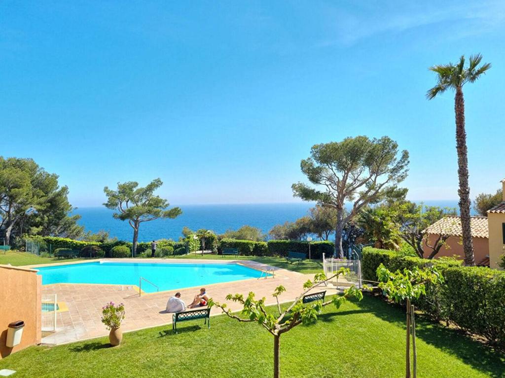 un complexe avec une piscine et l'océan dans l'établissement Résidence CAP SOLEIL, piscines, tennis..., à Saint-Mandrier-sur-Mer