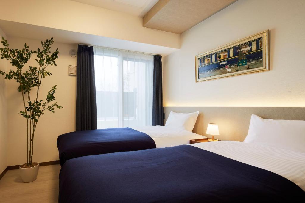 Postel nebo postele na pokoji v ubytování Minn Kitahiroshima Station East