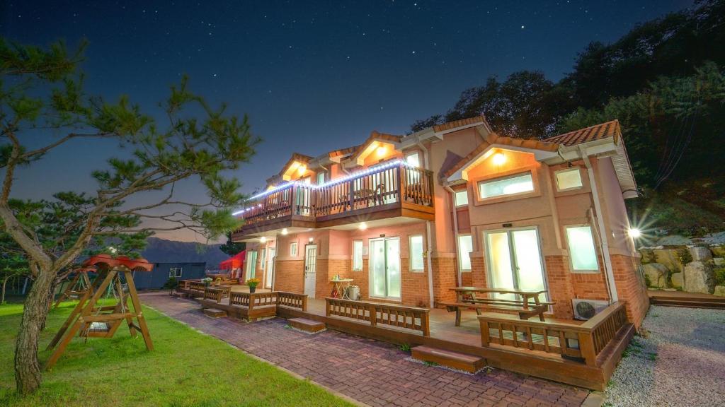a large house with a deck at night at Pocheon Swimpyo Pension in Pocheon
