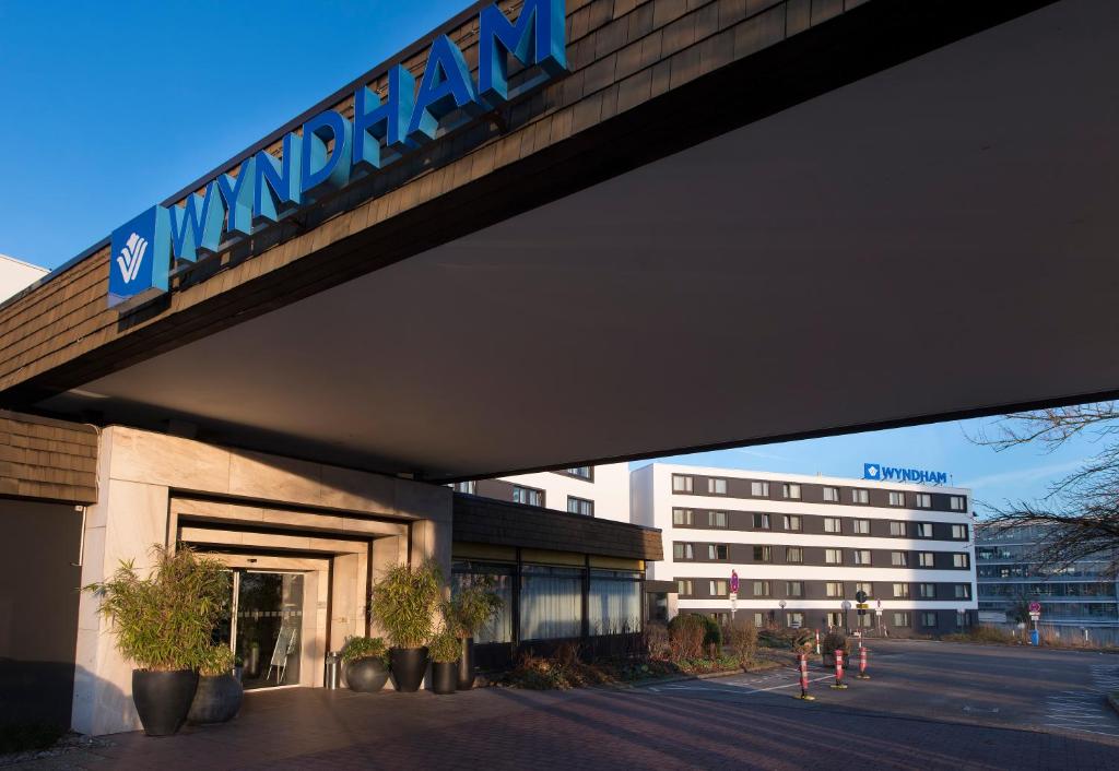 a building with a sign on top of it at Wyndham Stuttgart Airport Messe in Stuttgart