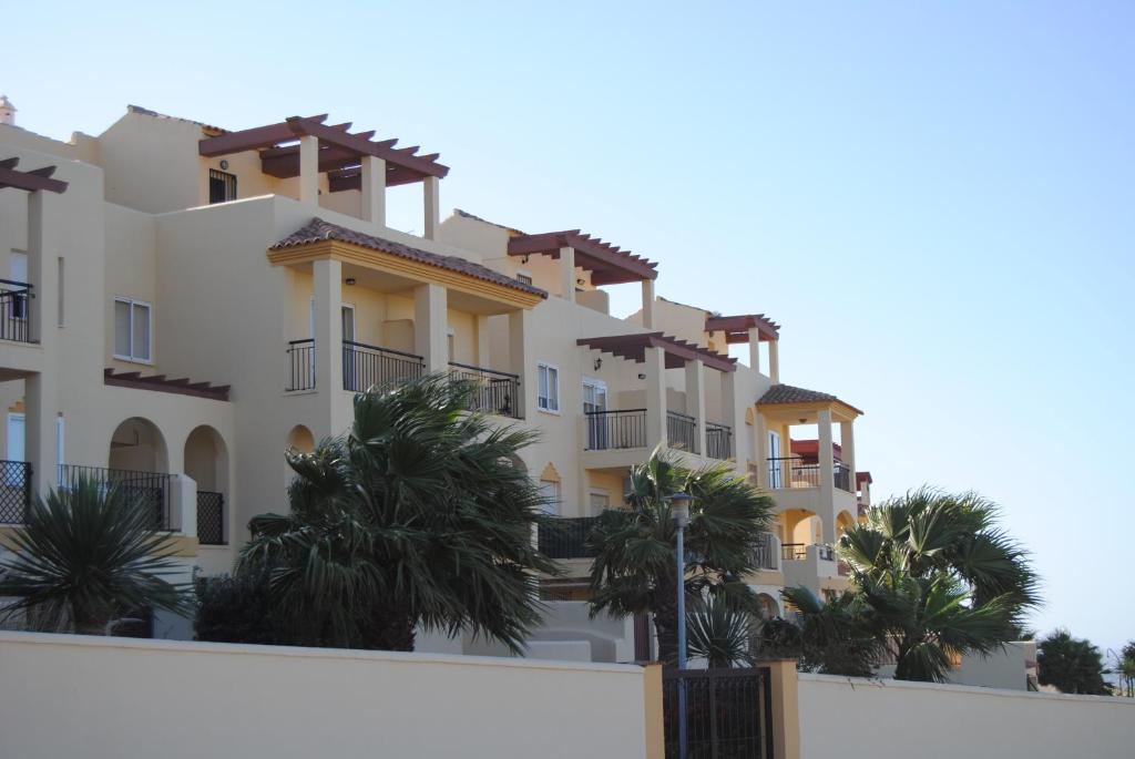 a building with palm trees in front of it at Apartamento con Piscina in Tarifa