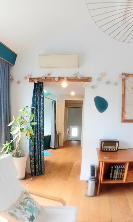 Il comprend un salon doté de murs blancs et de parquet. dans l'établissement Appartement privé avec terrasse en centre ville, à Montpellier