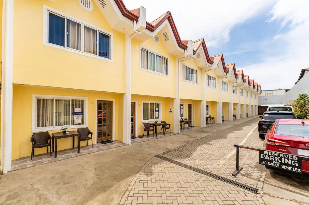 un edificio con tavoli e auto parcheggiate in un parcheggio di Laciaville Resort and Hotel a Lapu Lapu City