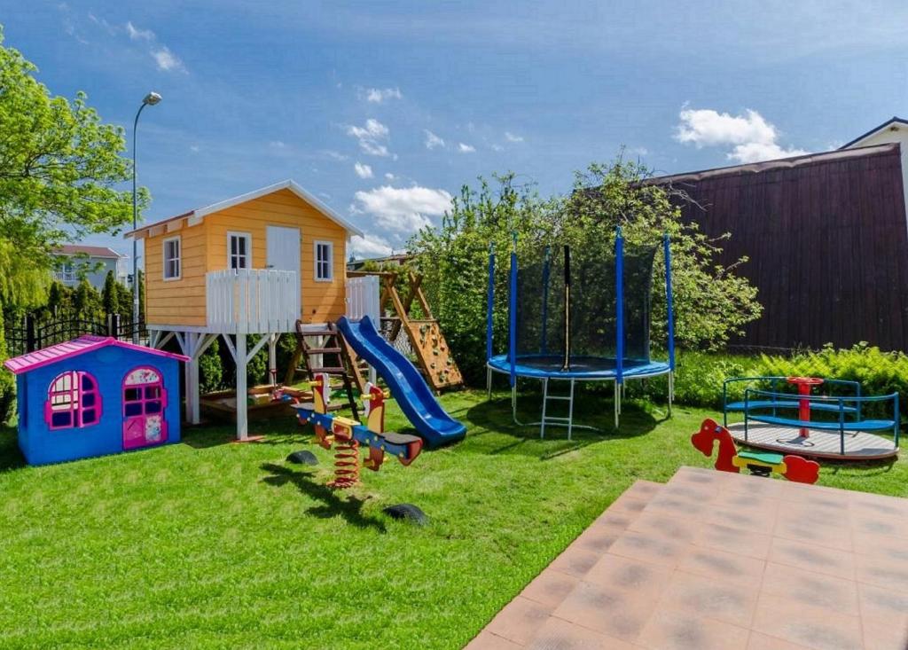 a backyard with a playground with a slide and a house at Pokoje Mariola in Karwia