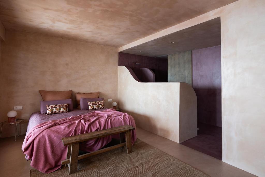 a bedroom with a bed with purple sheets and a bench at Formentera Especial in La Savina