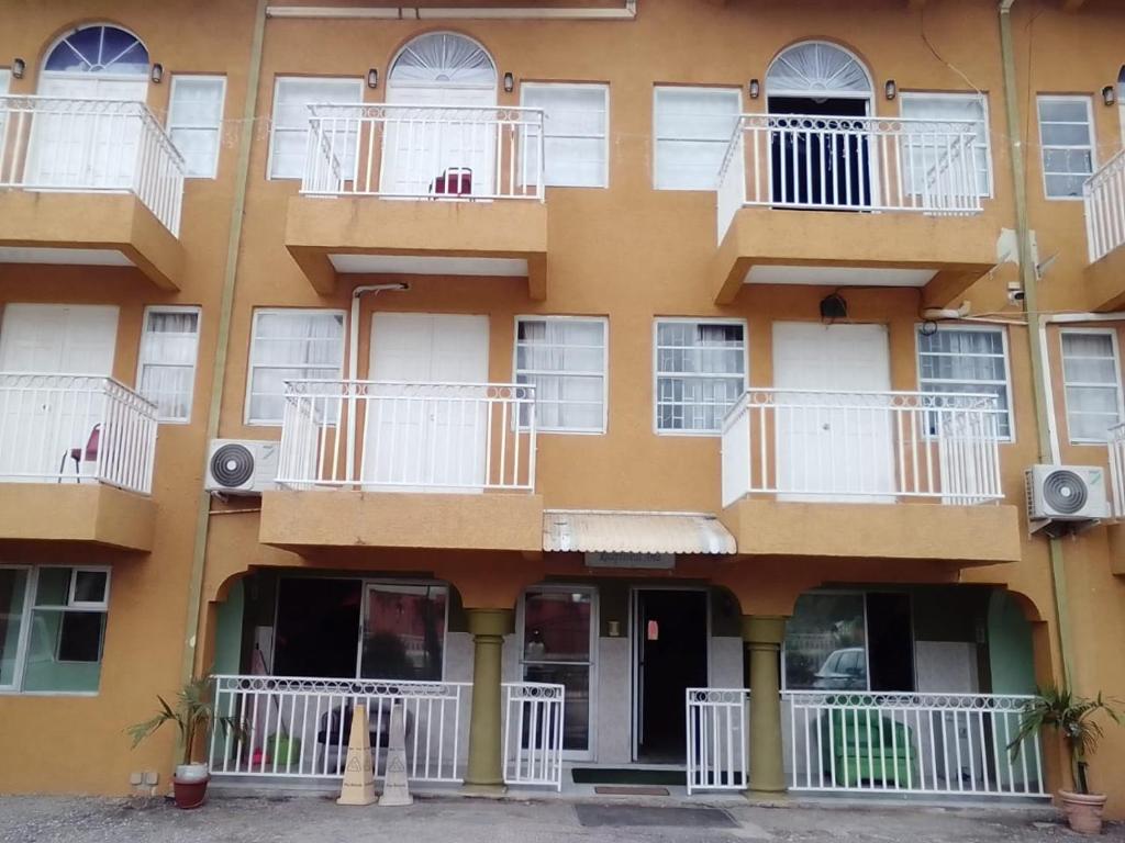 an apartment building with white balconies and windows at Kibo Hotel in Savanna-la-Mar