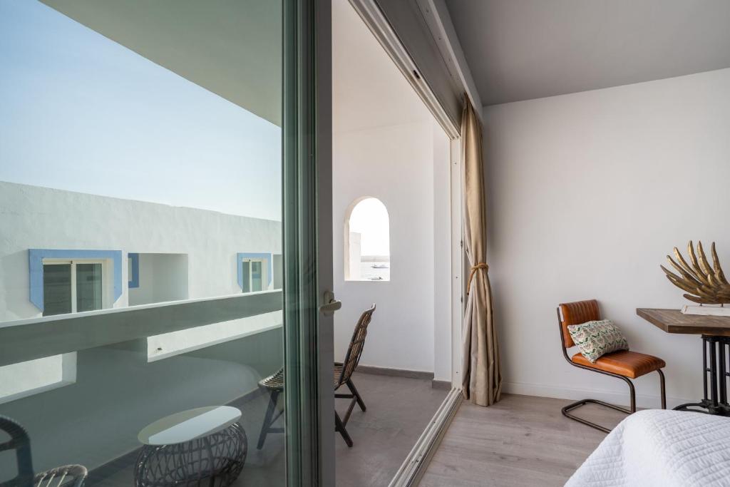 a room with a bed and a table and a window at Formentera Especial in La Savina