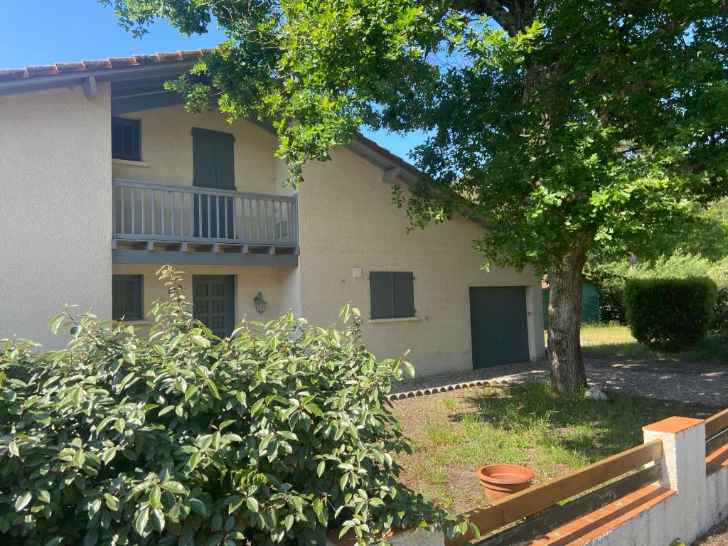 une maison avec un arbre devant dans l'établissement Maison au calme à proximité du lac, à Maubuisson