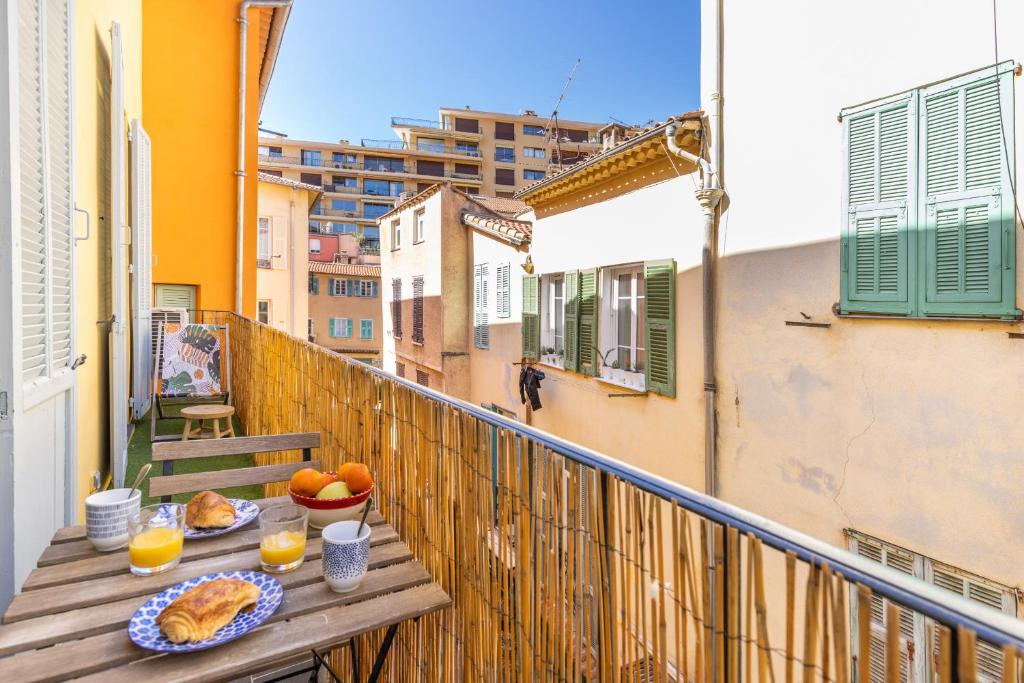 une table avec de la nourriture et des oranges sur un balcon dans l'établissement Appartement de charme centre vieux village, à Villefranche-sur-Mer