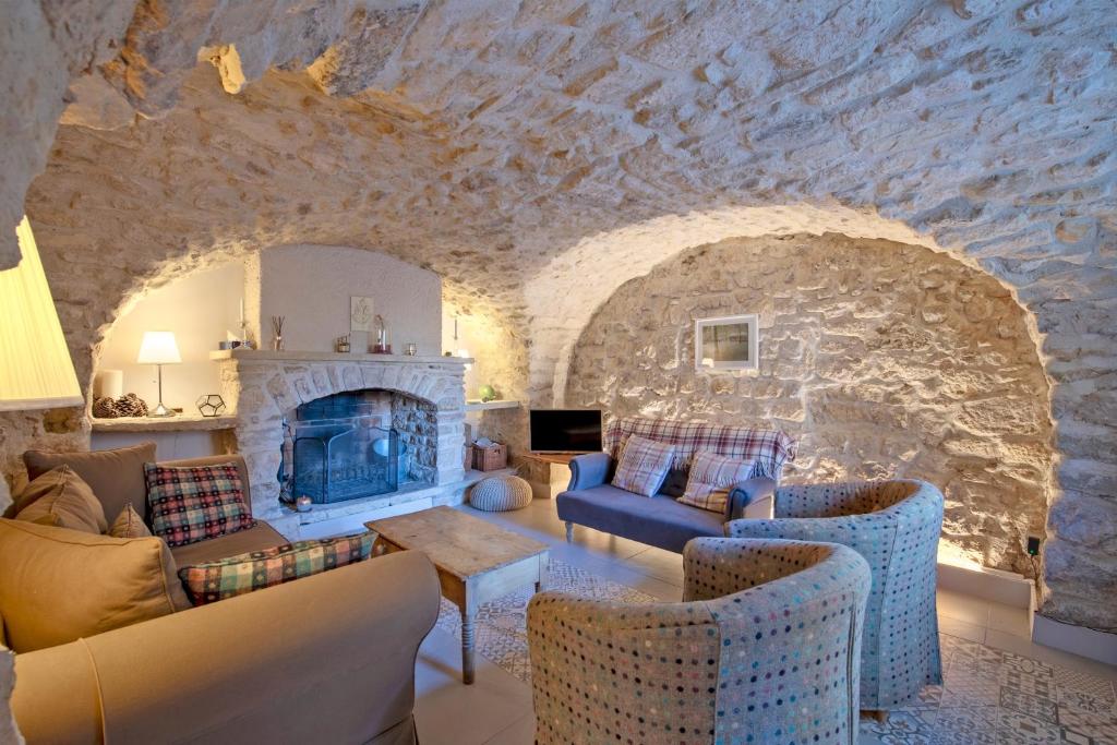 - un salon avec un grand mur en pierre dans l'établissement Le Cœur de Garrigues - Piscine Privée, à Garrigues-et-Sainte-Eulalie