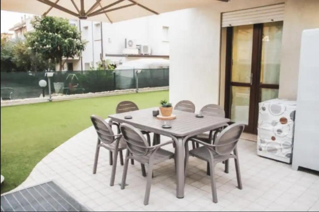 uma mesa de jantar e cadeiras num pátio em Vicina al mare con grande giardino - Appartamento Tulipano em Rimini