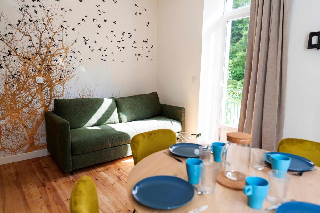 - un salon avec une table et un canapé vert dans l'établissement Gîte Col Vert - Ski - Domaine, à Villard-de-Lans