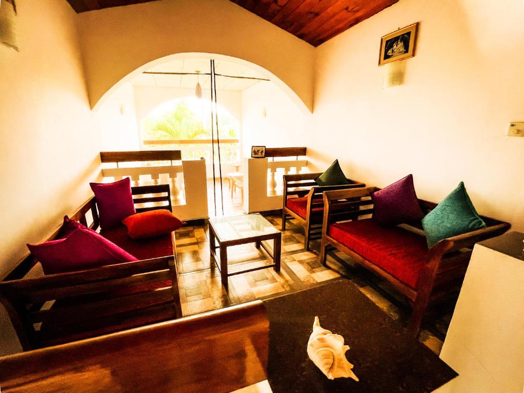 a living room with couches and a table at Rohans place in Nattandiya