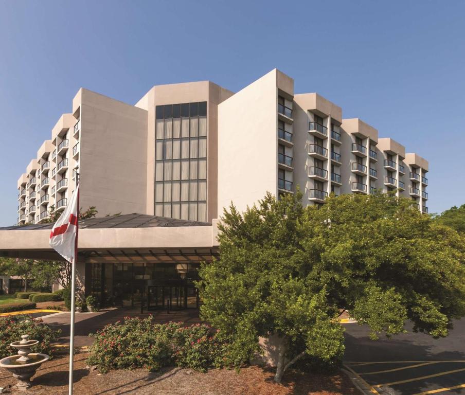 a building with a flag in front of it at Embassy Suites Birmingham in Birmingham