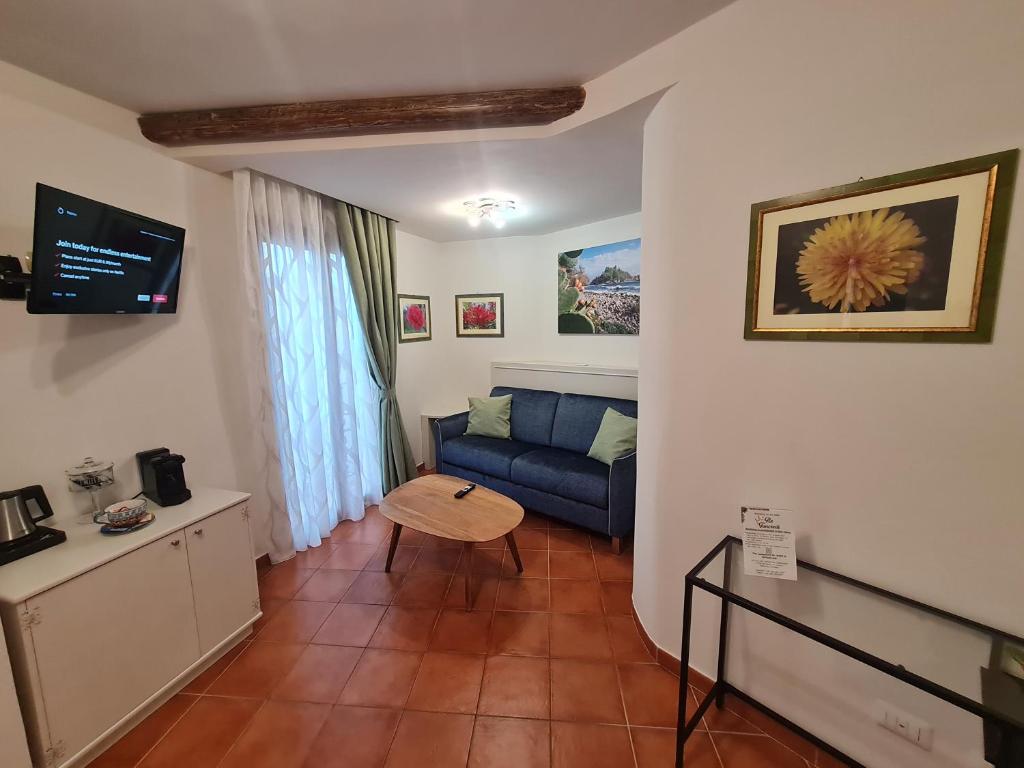 a living room with a blue couch and a table at B&B RE TANCREDI in Taormina