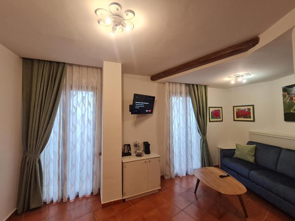 a living room with a blue couch and a table at B&B RE TANCREDI in Taormina