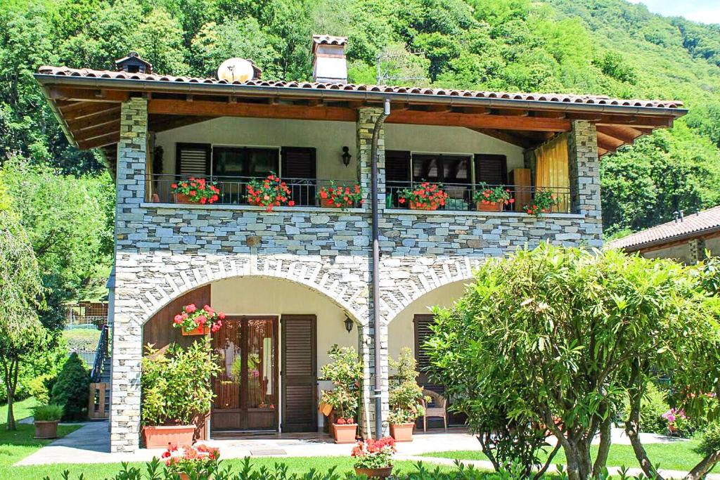 a house with a balcony with flowers on it at Piccola Oasi in Cannobio
