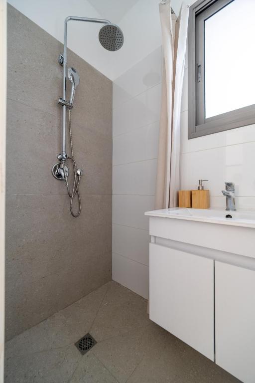 a bathroom with a shower and a sink at Urban Nest Yaavetz Tlv in Tel Aviv