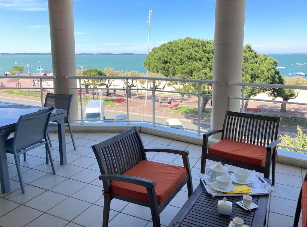 d'un balcon avec des chaises, une table, une table et des chaises. dans l'établissement APPARTEMENT T3 VUE MER grande terrasse, à Arcachon