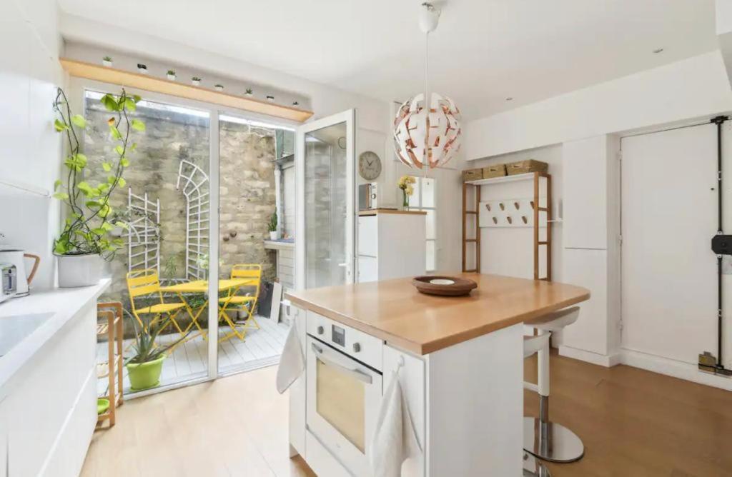 une cuisine avec des appareils blancs et une grande fenêtre dans l'établissement Appartement familial face pantheon - Paris 5 4P, à Paris