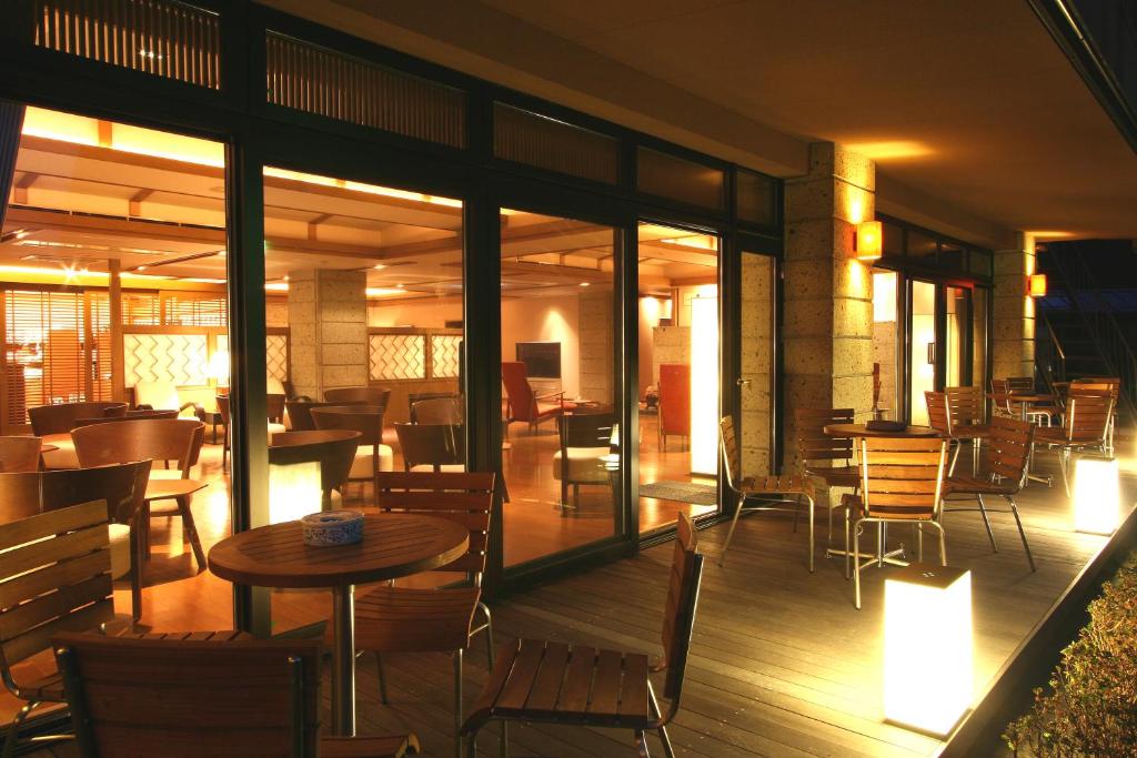 a restaurant with tables and chairs on a deck at Senkyoro in Hakone