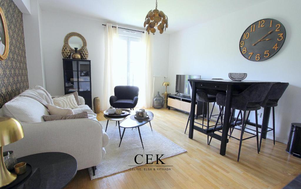 - un salon avec une table et une horloge murale dans l'établissement Victoria1 - Nice apartment 4ppl near Disneyland, à Serris