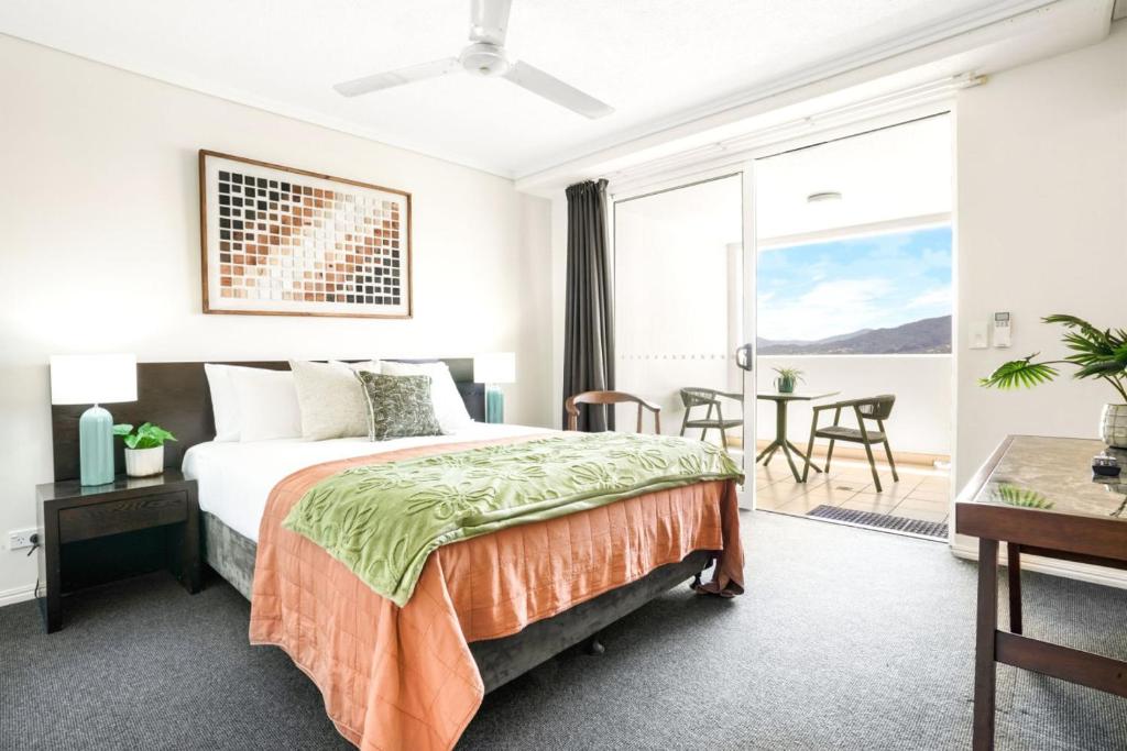 a bedroom with a bed and a table with chairs at Cairns Central Studio 1012 Rooftop Shared Pool & CBD Location in Cairns