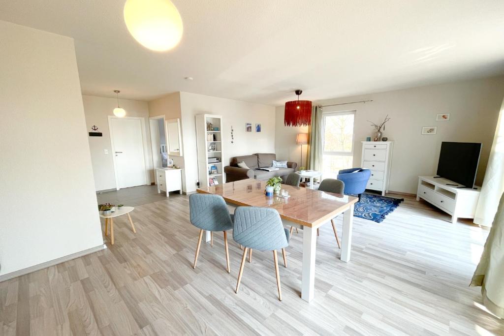 une salle à manger et un salon avec une table et des chaises dans l'établissement Strandstrasse 21 Ferienwohnung Domizil Auszeit, à Kolpinsee