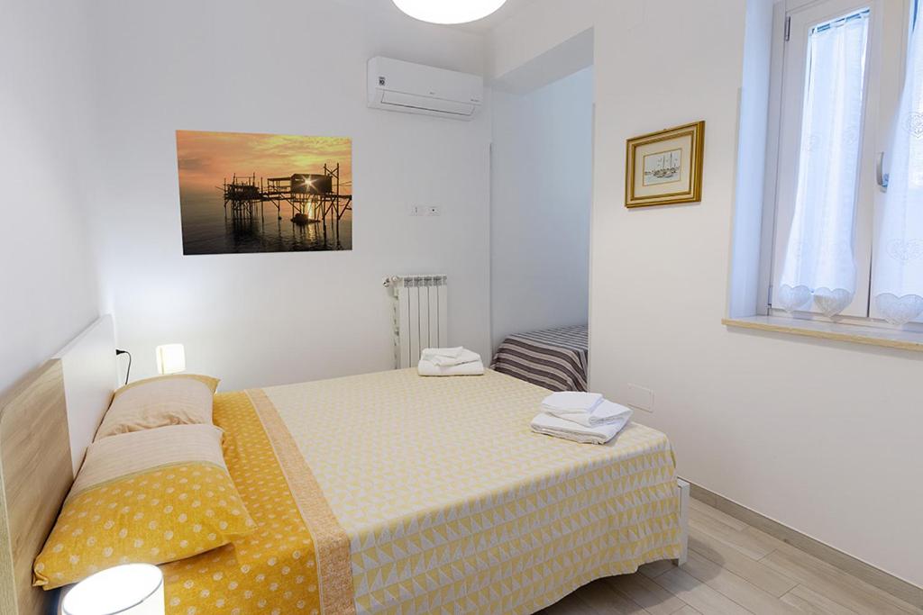 Un dormitorio con una cama en una habitación blanca. en Colibrì Apartament, en Lanciano