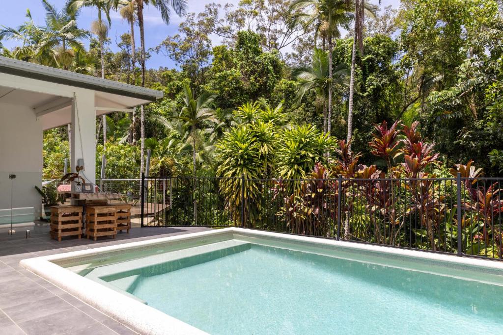 a swimming pool in front of a house at Rainforest Retreat in Bamboo in Miallo