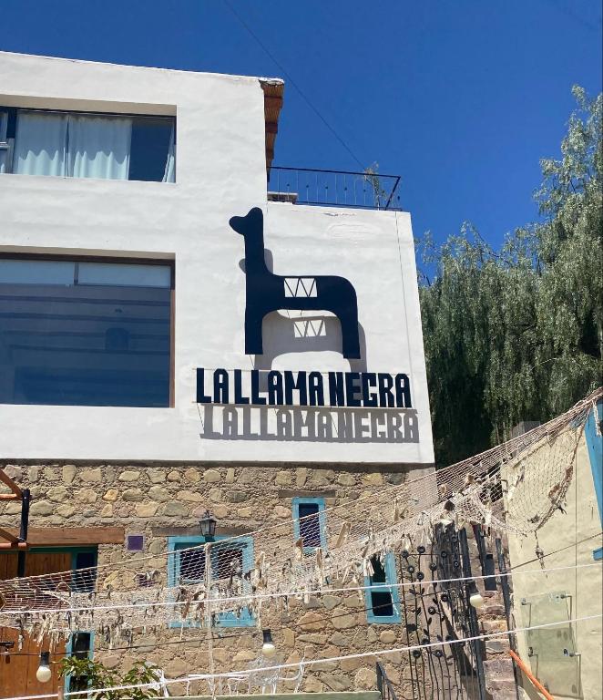 un cartel en el costado de un edificio en La Llama Negra, en Tilcara