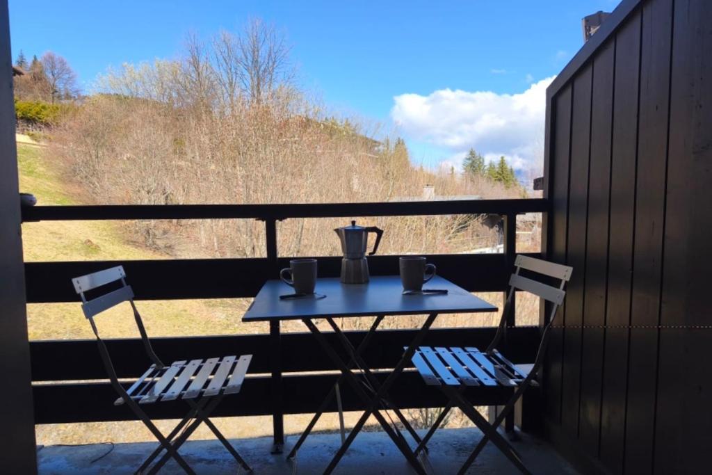 d'une table avec deux chaises et d'un pitcher sur le balcon. dans l'établissement Cozy Apartment with Balcony Saint-Gervais, à Saint-Gervais-les-Bains