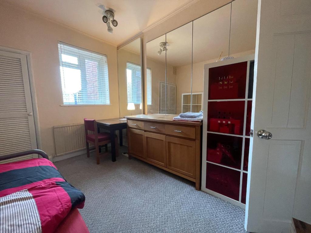 a bedroom with a desk and a table with a mirror at Single room 10 minutes to Central London in London