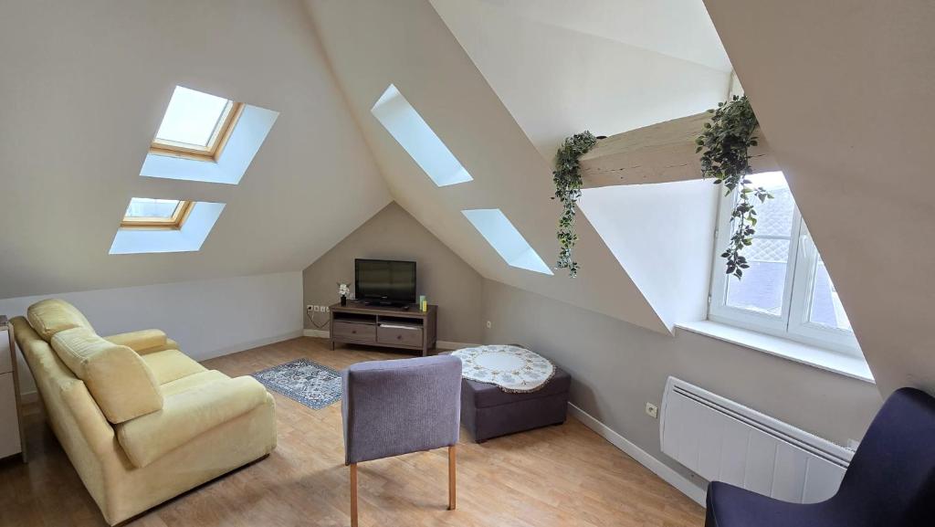 a attic living room with skylights and a couch and a tv at Le Voyageur A la plage vue mer in Berck-sur-Mer