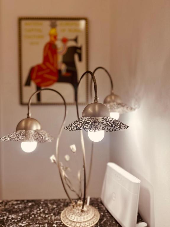a lamp on a table with a picture on the wall at La Maison de la Dame in Matera