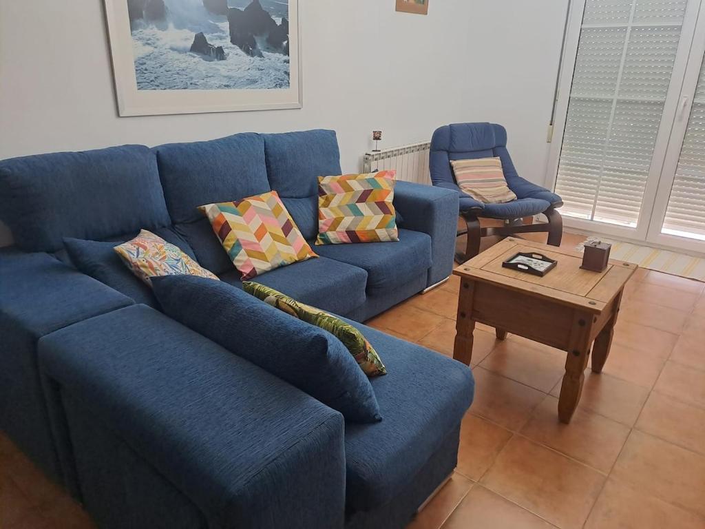 a living room with a blue couch and a coffee table at El Mirador del Esla in Villanueva de las Manzanas