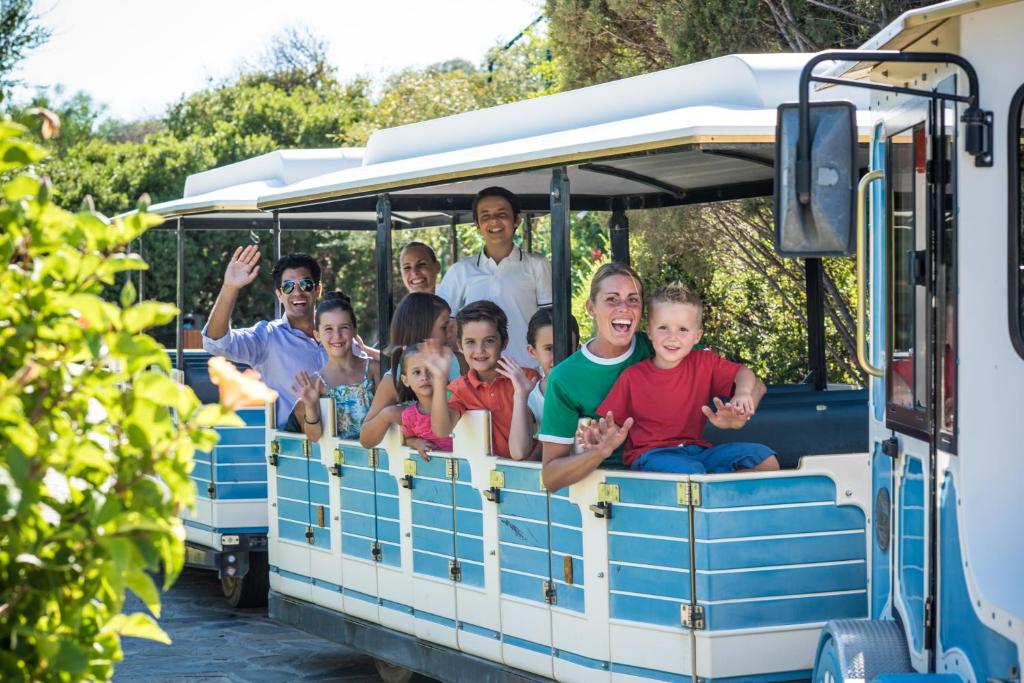 a group of people riding on a small train at Chia Laguna - Hotel Village in Chia