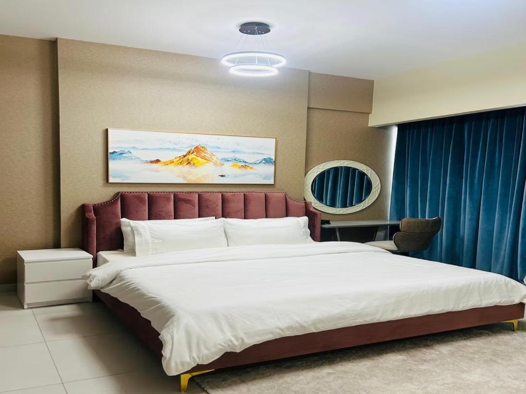 a bedroom with a large bed with a red headboard at MontRose residence Tower A 1BR Apartment in Dubai
