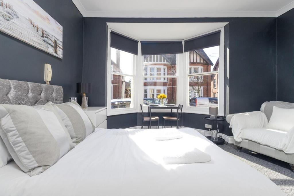 a bedroom with a large white bed and a chair at NEW! Central Studio, Free Parking, WiFi, 5 Min to Train Station in Spon End