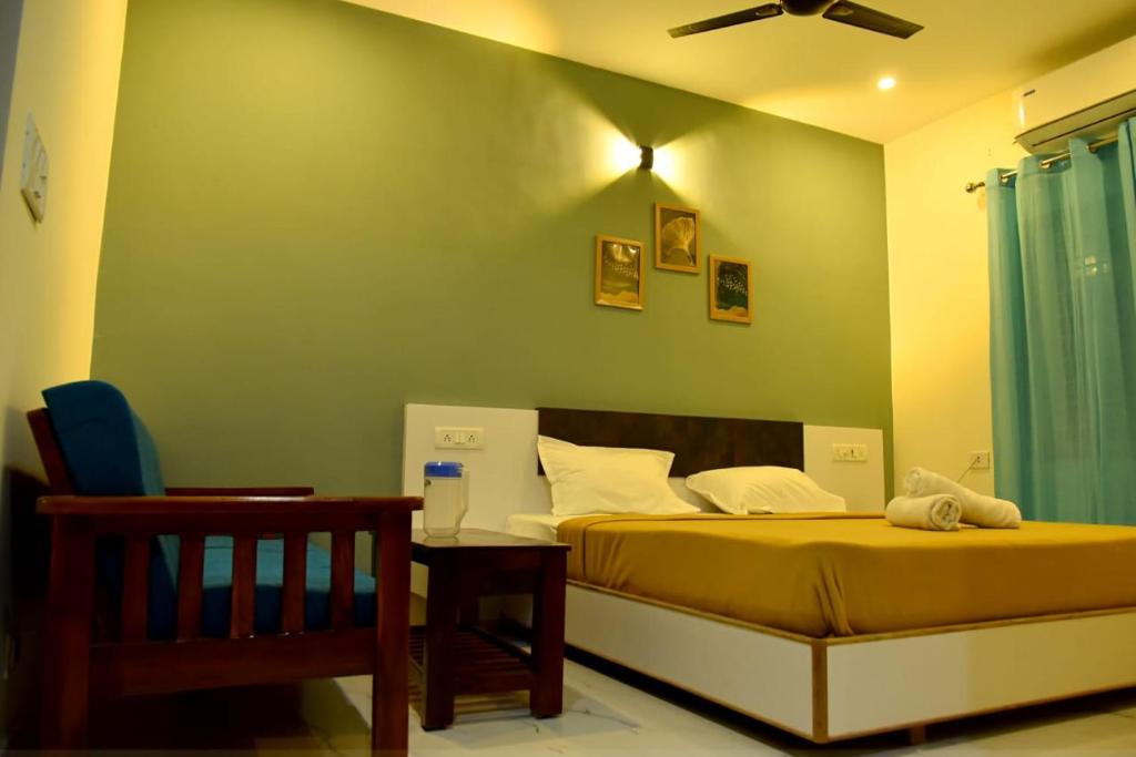 a bedroom with a bed with a green wall at Nilton Bay Residency in Kottakupam