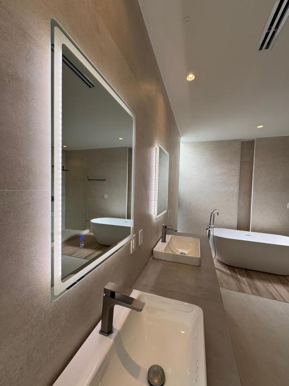a bathroom with a sink and a tub and a mirror at Luxury Exclusive Villa in Playa del Carmen