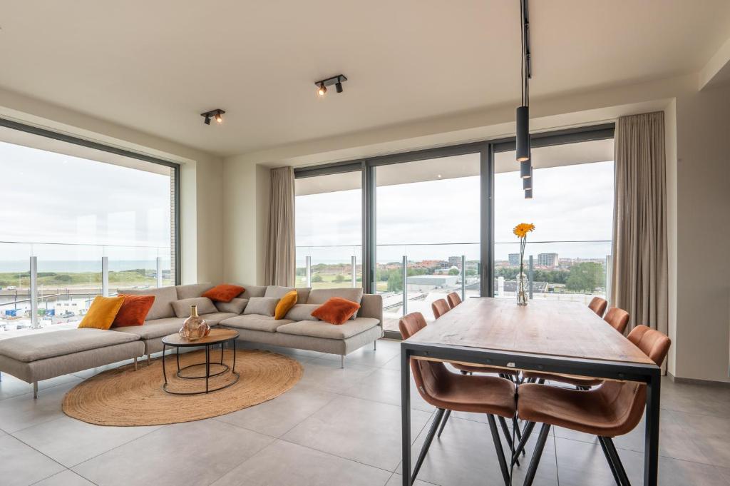 a living room with a couch and a table at Luxurious new apartment with stunning views in Ostend