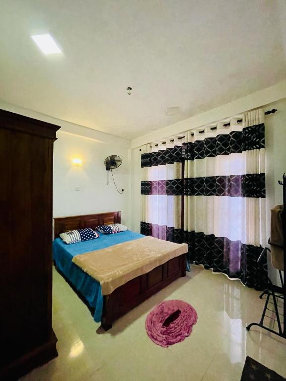 a bedroom with a bed and a window with curtains at Devil mountain guest in Kalupahana