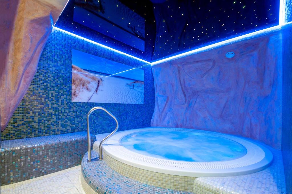 米兹多洛杰Monaco Ville Wellness的浴室配有带蓝光的热水浴池